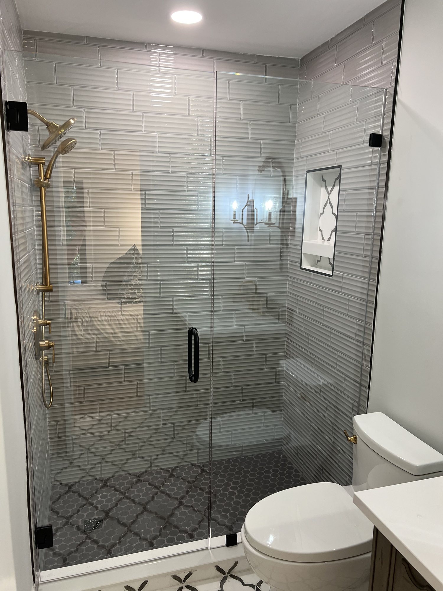 Modern shower with brass fixtures and fluted tile