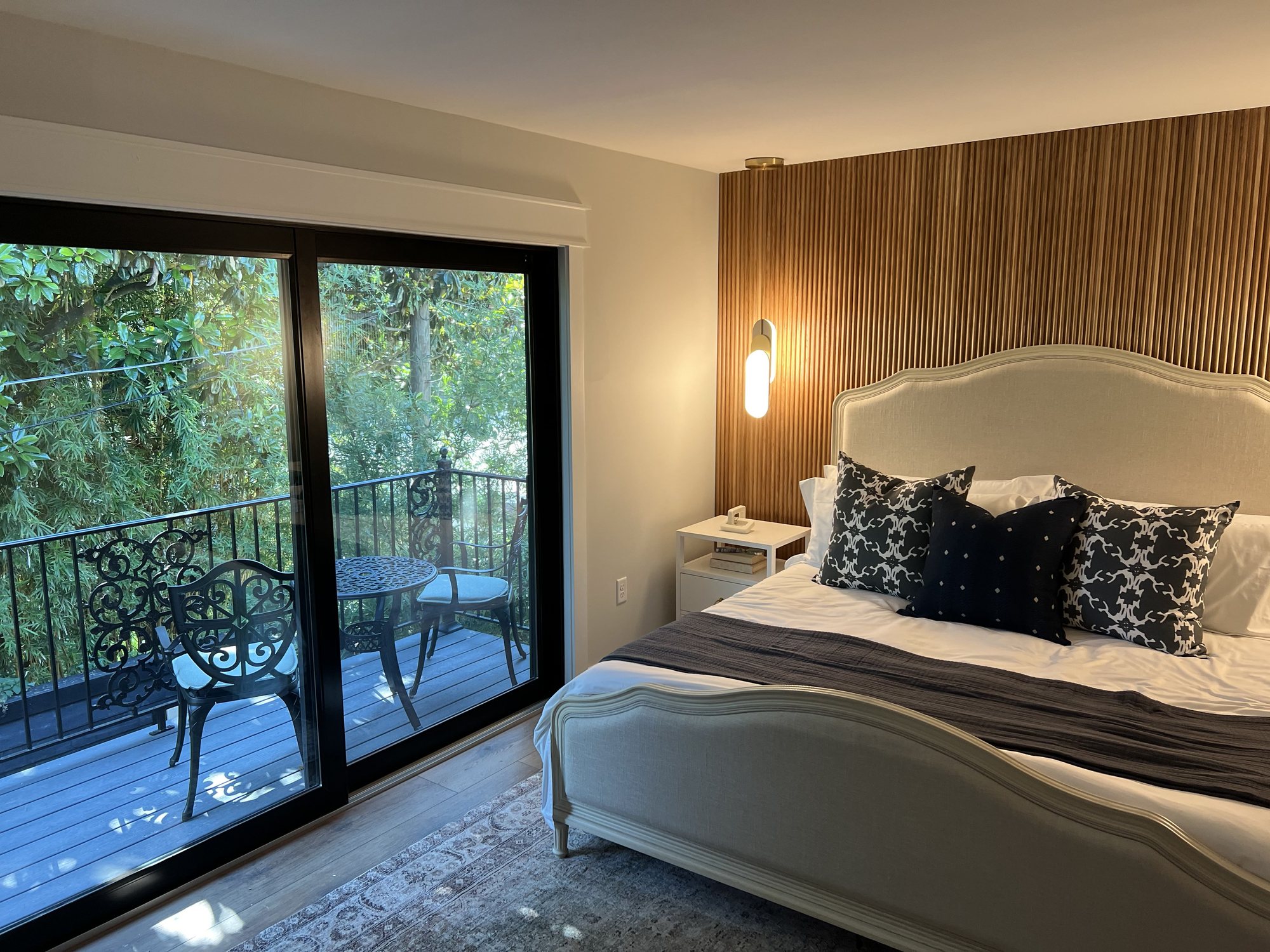 HGTV home bedroom with fluted wood wall and balcony