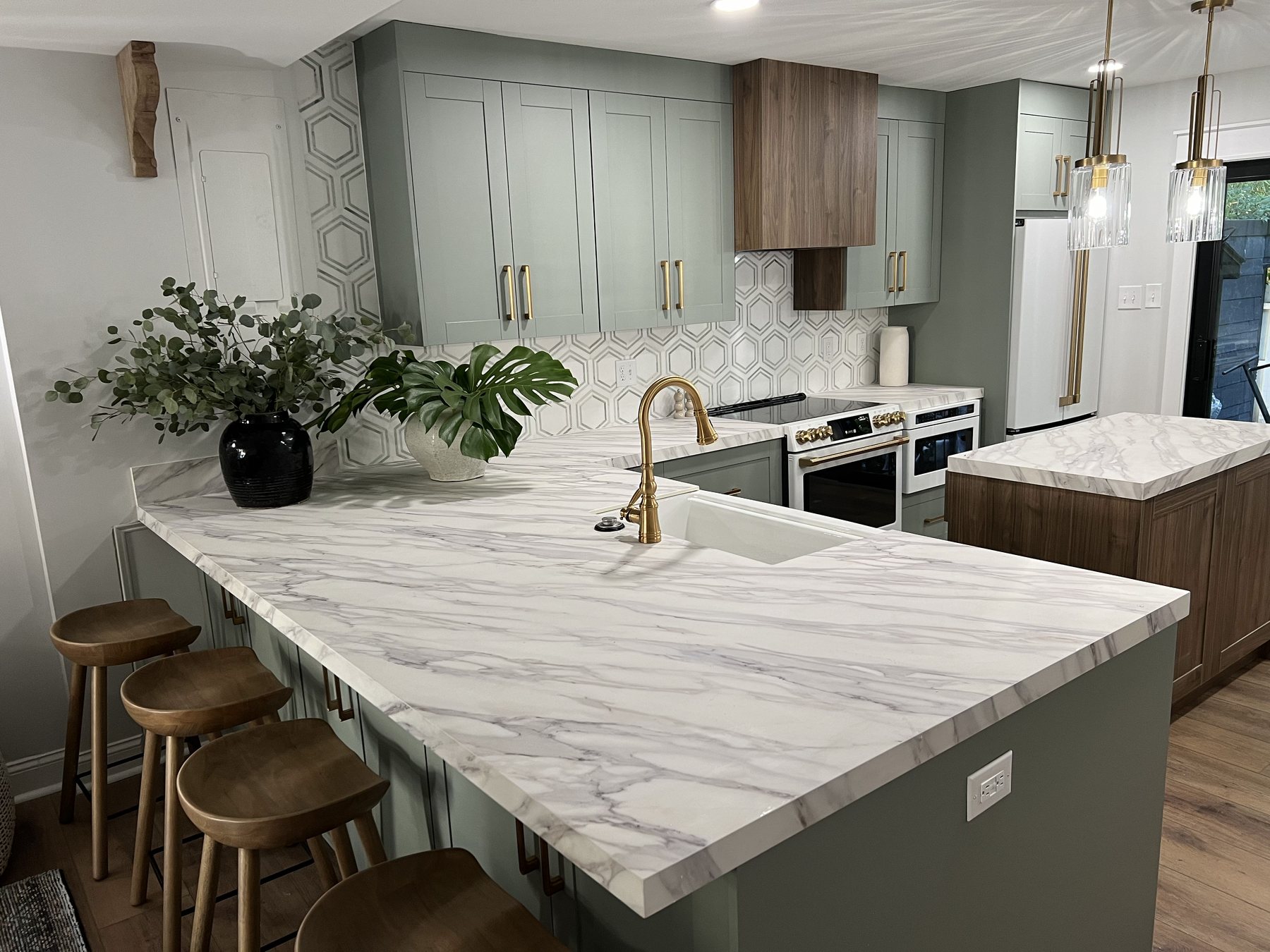 Sage green kitchen with marble waterfall island