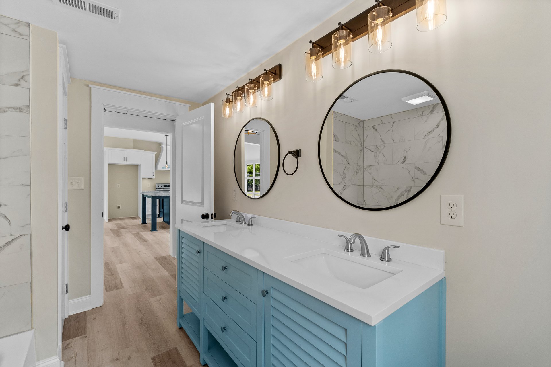Bathroom with blue vanity and round mirrors